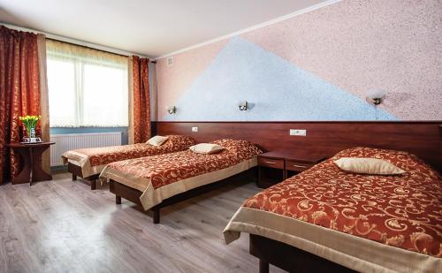 um quarto de hotel com duas camas e uma grande janela em Hotel Irys em Lublin