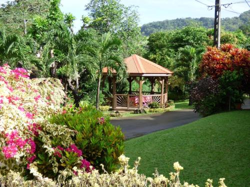 a gazebo in a garden with flowers at Villa Hausseman in Rivière-Pilote