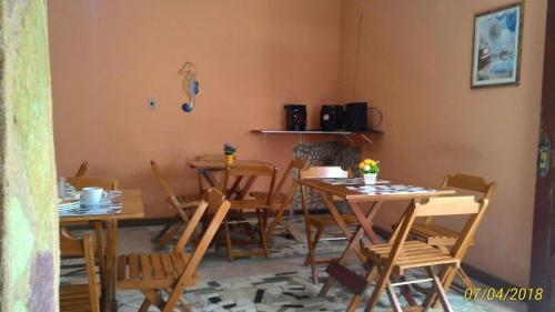 une salle à manger avec des tables et des chaises en bois dans l'établissement Pousada Montreux, à Praia do Forte
