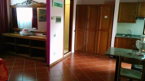 a kitchen with a red tile floor and wooden cabinets at Motorrad-Hotel Toskana con piscina e giardino nel Chianti in Montespertoli