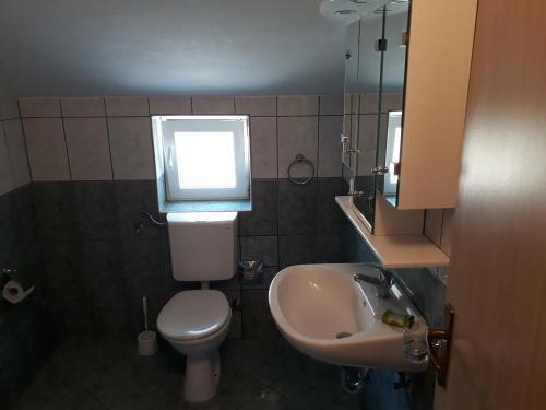 baño con aseo y lavabo y ventana en Apartment Ivana, en Viganj
