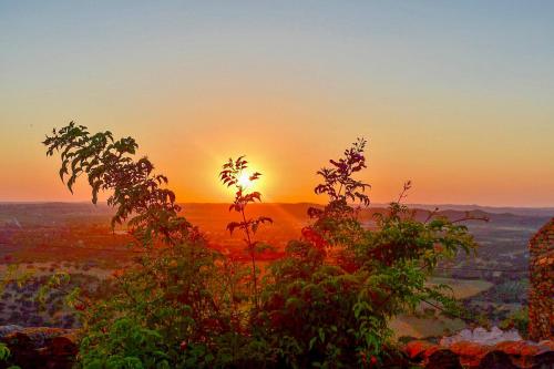 a sunset from the top of a hill with trees at Casa D’ Santiago in Monsaraz