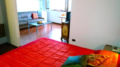 a living room with a red bed and a couch at Motorrad-Hotel Toskana con piscina e giardino nel Chianti in Montespertoli