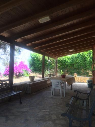 eine Terrasse mit einem Tisch, Stühlen und einem Fenster in der Unterkunft Villa “La Giummarra” - Scivolo di Cornino in Custonaci