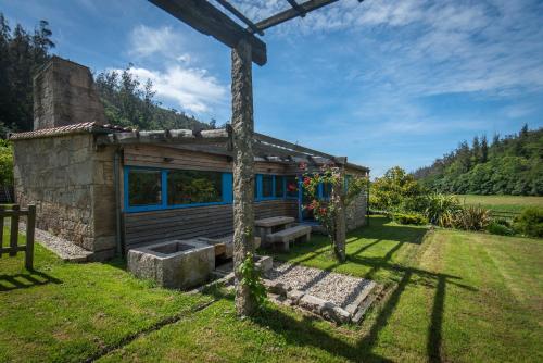 a log cabin with a picnic bench in a yard at A Cabana de Carmen in Cabana Moura 