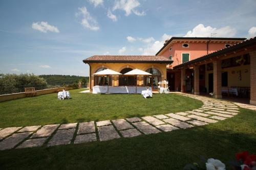 a patio with a table and chairs in a yard at Agriturismo Spigolo in Avesa