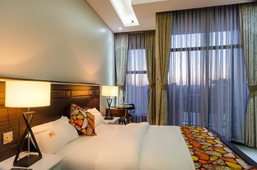 a hotel room with a large bed and windows at The Venti Hotel & Spa in Kampala