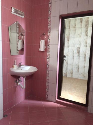 a pink bathroom with a sink and a mirror at Villa Varna View in Varna City