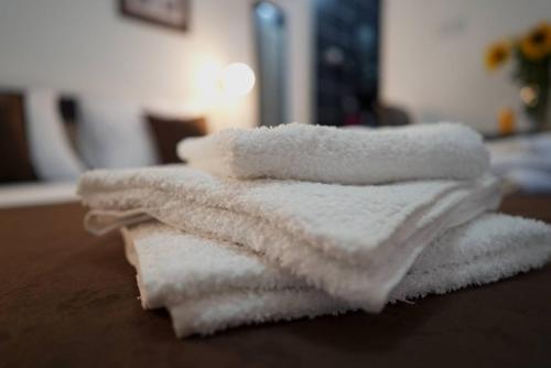 a stack of white towels sitting on a table at Apartments & Dream Rooms in Niš