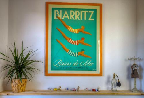 a picture on a wall above a shelf at Maison de la riviere in Autevielle-Saint-Martin-Bideren
