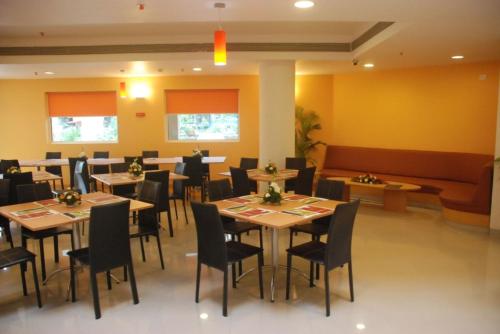 a dining room with wooden tables and chairs at Ginger Nashik in Nashik