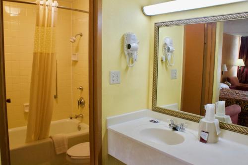 a bathroom with a sink and a toilet and a mirror at Relax Inn - Monroe in Monroe