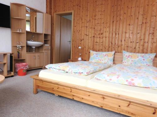 a bedroom with two twin beds and a television at Hotel Pension am Kurmittelhaus in Bad Grund