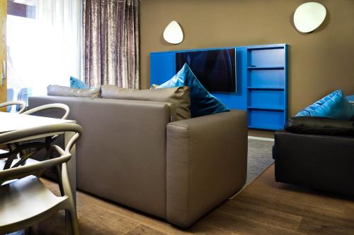 sala de estar con sofá y TV en Sweet Life Villas, en Peschiera del Garda