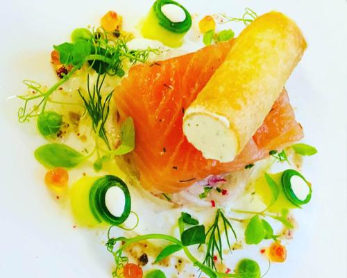 a plate of food with fish and a piece of bread at Hotel Lauterbad in Freudenstadt