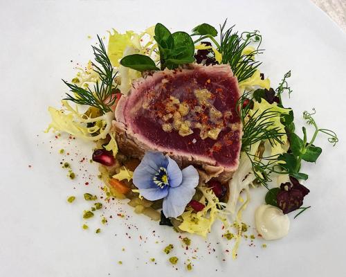 a plate of food with a piece of meat and vegetables at Hotel Lauterbad in Freudenstadt