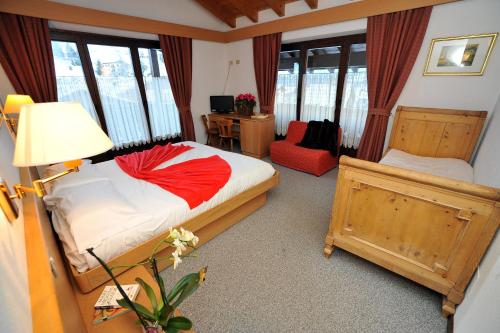 a bedroom with a bed and a desk with a chair at Hotel Derby in Bormio