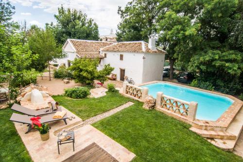 un patio trasero con piscina y una casa en Casa Rural La Alameda, en Madridejos