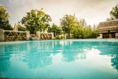 a large swimming pool with blue water at Casa Rural La Alameda in Madridejos