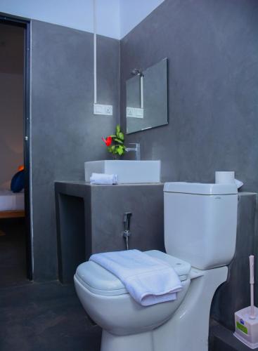 a bathroom with a white toilet and a sink at Hotel Star White - Negombo in Negombo