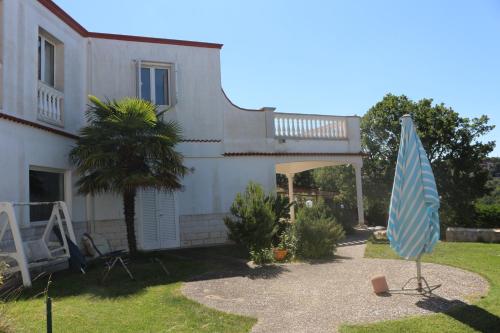 a blue umbrella in the yard of a house at B&B Belvedere in Cassano delle Murge