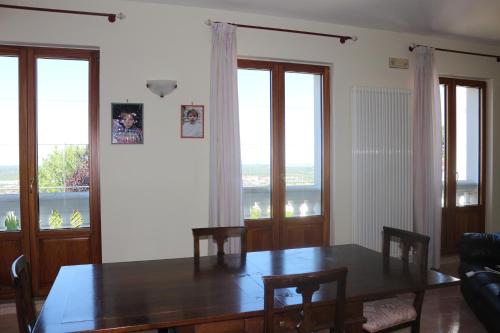 a dining room with a table and two windows at B&B Belvedere in Cassano delle Murge