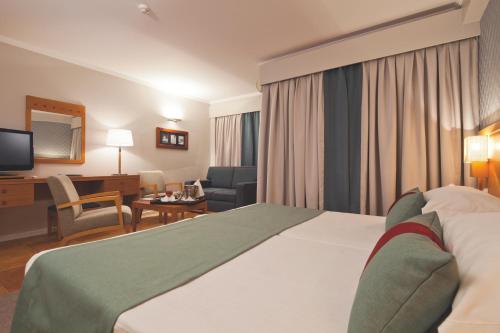 a hotel room with a large bed and a desk at Eurotel Altura in Altura