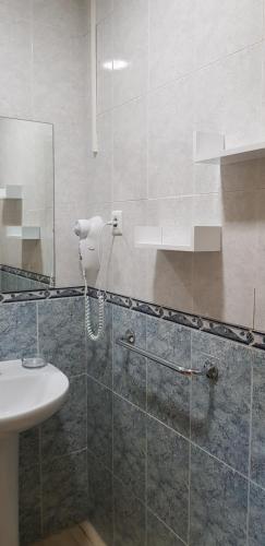 La salle de bains est pourvue d'un lavabo et d'un miroir. dans l'établissement Pension San Marcos, à Alovera