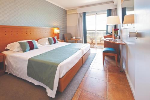 a hotel room with a large bed and a desk at Eurotel Altura in Altura