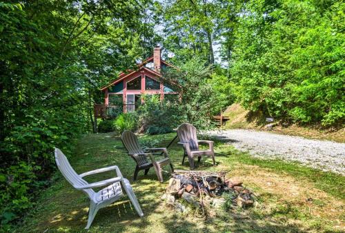 three chairs sitting around a fire in front of a cabin at Nantahala Cabins in Bryson City