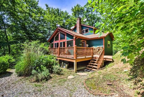 a small house with a large deck on a hill at Nantahala Cabins in Bryson City