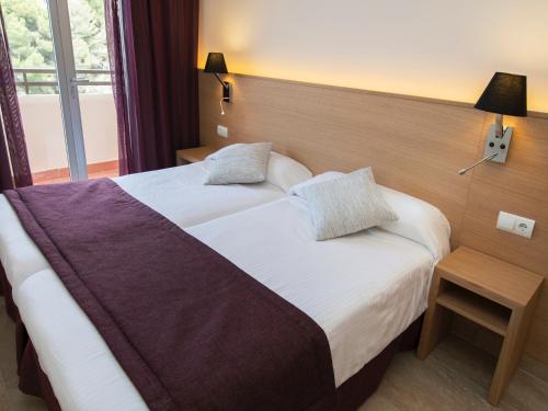 Cette chambre comprend 2 lits et une fenêtre. dans l'établissement Apartamentos San Miguel Park & Esmeralda Mar, à Port de Sant Miguel