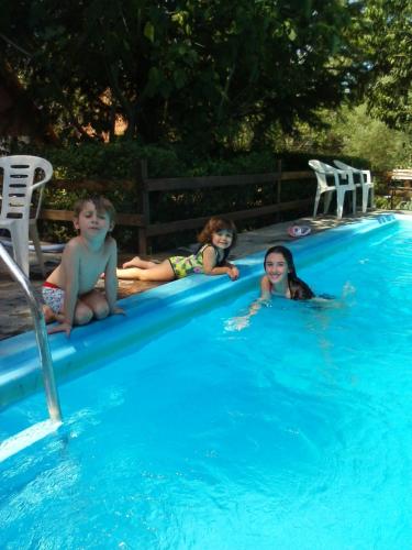 a group of children laying in a swimming pool at Cabañas Ñuke Mapu in Villa Ventana