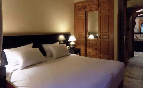 a bedroom with a large white bed with two pillows at Palmeraie village in Marrakesh