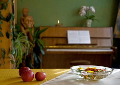 a bowl of fruit on a table with a plate of food at Tourist Farm Kranjc in Kobarid
