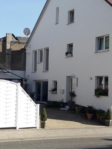 a white house with a white fence in front of it at Gemütliche Zimmer in Kaisersesch