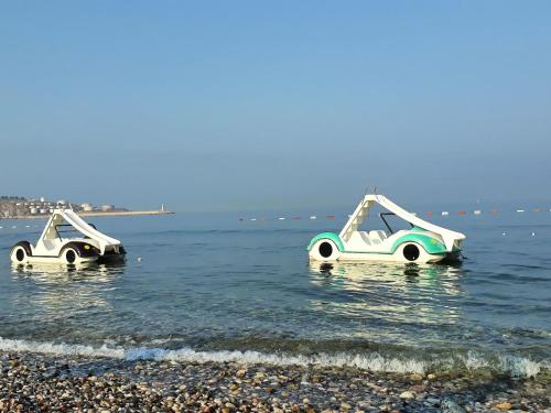 two boats floating in the water on a beach at Apartments Kuce Lekovica Beach & snack bar- Bistro in Bar