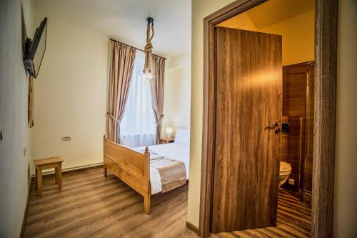 a bedroom with a bed and a large wooden door at La Maisonnette in Braşov