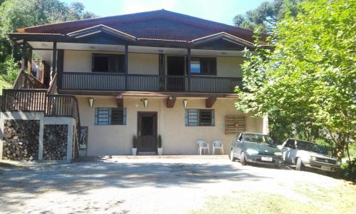 Apartamento Bella Vista Gramado في غرامادو: منزل فيه سيارة متوقفة أمامه
