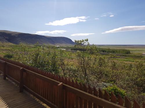 a wooden deck with a view of a field at Gljúfurbústaðir Holiday Homes in Hveragerði