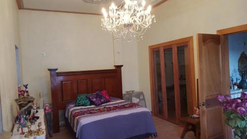 a bedroom with a bed and a chandelier at La Casona Azul Bed n Breakfast in Santa Rosa de Jáuregui