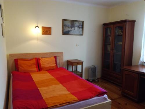 a bedroom with a bed with a colorful blanket at Domek Drewniany in Nowa Wola