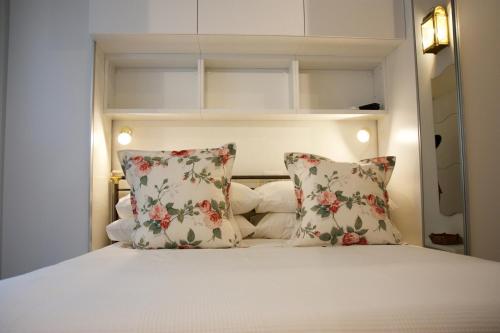 a small bedroom with a bed with two pillows at Renovated Central Suites in Florence