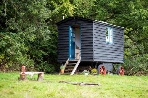 ein kleines schwarzes Haus auf einem Feld in der Unterkunft Beautiful, Secluded Shepherd's Hut in the National Park in Rake