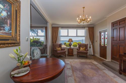 a living room with a wooden table and chairs at On The Point - Lake Rotorua in Rotorua