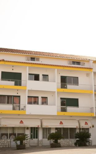 an apartment building with balconies and trees at Suites Do Pinhal in Proença-a-Nova