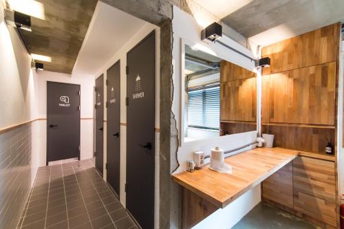 a bathroom with a wooden counter and a hallway with two doors at The Cube Hotel in Seoul