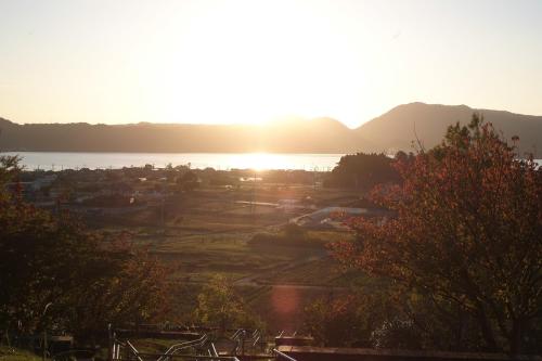 a view of the sun setting over the water at COCORETO The Guesthouse Daikon Island in Matsue