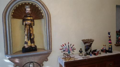 a room with a mirror with a statue on a shelf at La Casona Azul Bed n Breakfast in Santa Rosa de Jáuregui