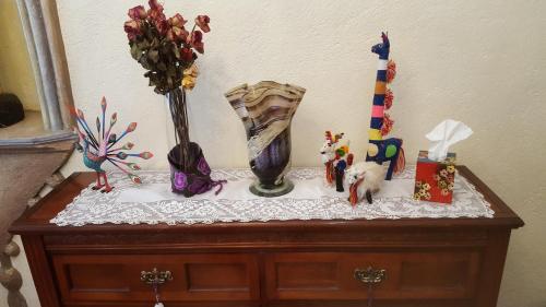 a table with a vase and decorations on it at La Casona Azul Bed n Breakfast in Santa Rosa de Jáuregui